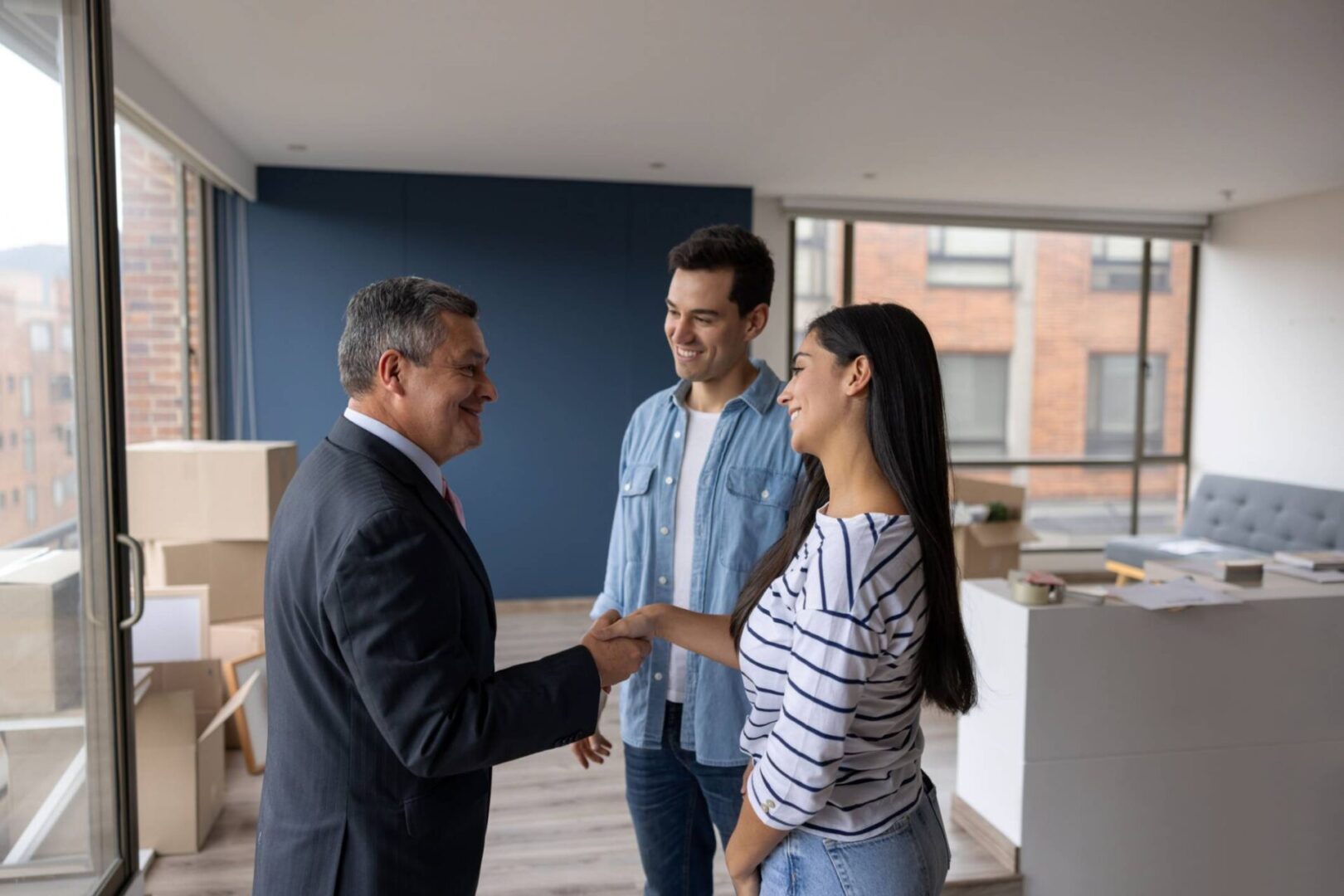Couple shaking hands with real estate agent.